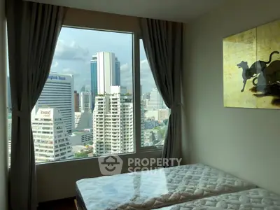 Spacious bedroom with stunning city view and modern decor in high-rise apartment.