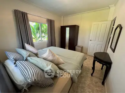 Cozy bedroom with elegant decor and lush garden view, perfect for relaxation.