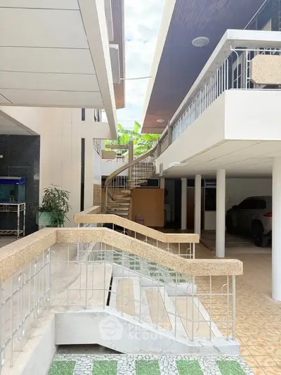 Modern multi-level building with unique architectural design and spacious parking area.