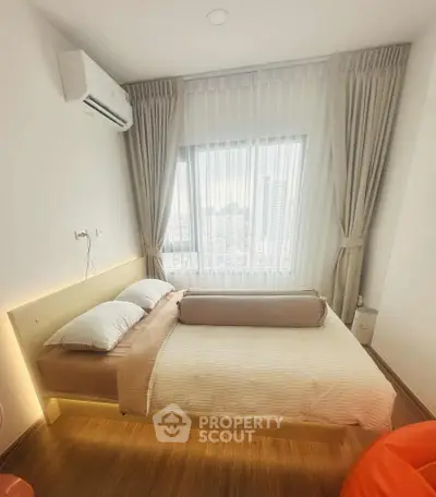Cozy bedroom with city view, featuring a comfortable bed and modern air conditioning.
