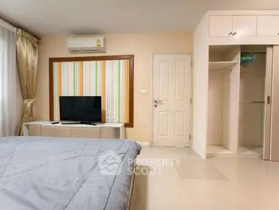 Modern bedroom with stylish decor and built-in storage in a cozy apartment.