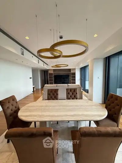 Luxurious open-plan living and dining area with modern furnishings and elegant lighting fixtures.