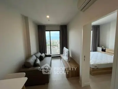 Modern apartment interior with living room and bedroom, featuring sleek furniture and a city view.