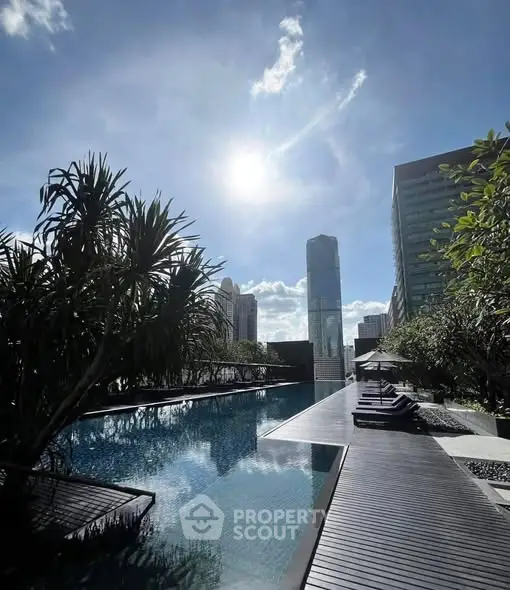 Luxurious rooftop pool with stunning city skyline view under a bright blue sky.