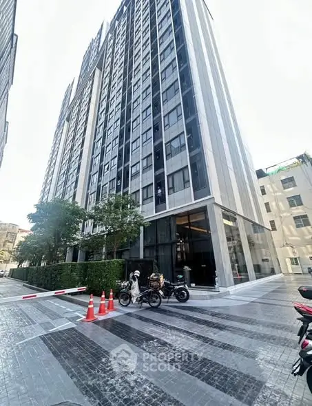 Modern high-rise building exterior with sleek design and urban surroundings.