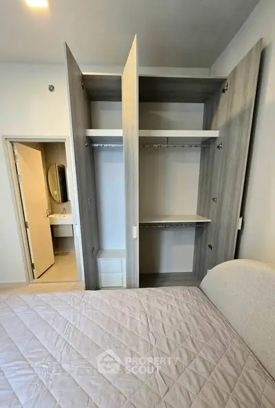 Spacious bedroom with open wardrobe and cozy bed in modern apartment