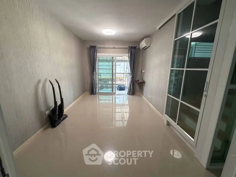 Spacious living room with large windows and modern decor, perfect for natural light and comfort.
