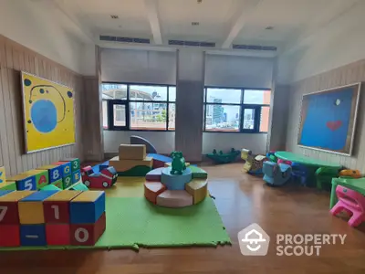 Spacious children's playroom with colorful toys and city view, perfect for family-friendly living.