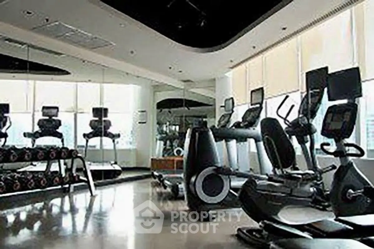 Spacious modern gym with state-of-the-art equipment and large windows.