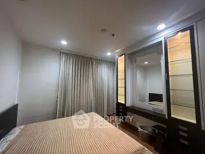 Spacious bedroom with elegant built-in wardrobe and soft lighting