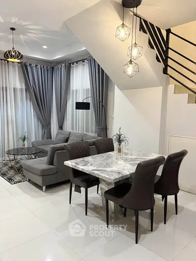 Modern living room with elegant dining area and stylish lighting fixtures