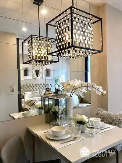 Stylish dining area with elegant chandelier and mirrored wall in modern apartment