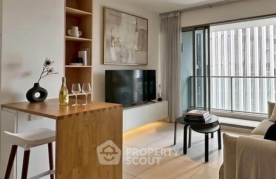Modern living room with balcony, stylish decor, and natural light.