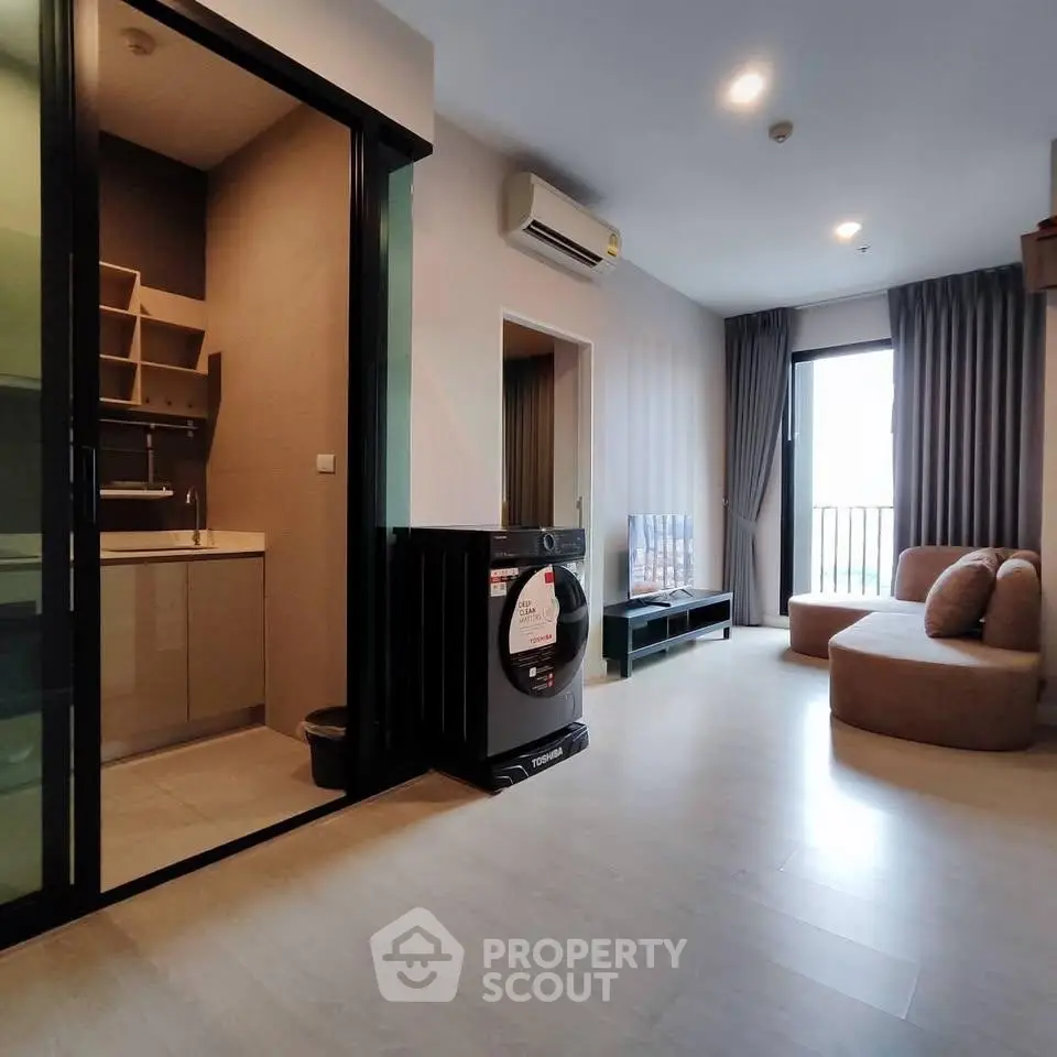 Modern living room with washing machine and balcony view in stylish apartment