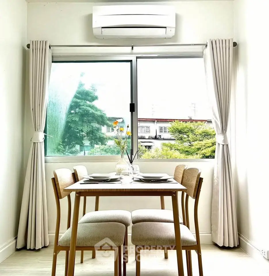 Bright dining area with window view and air conditioning, perfect for cozy meals.