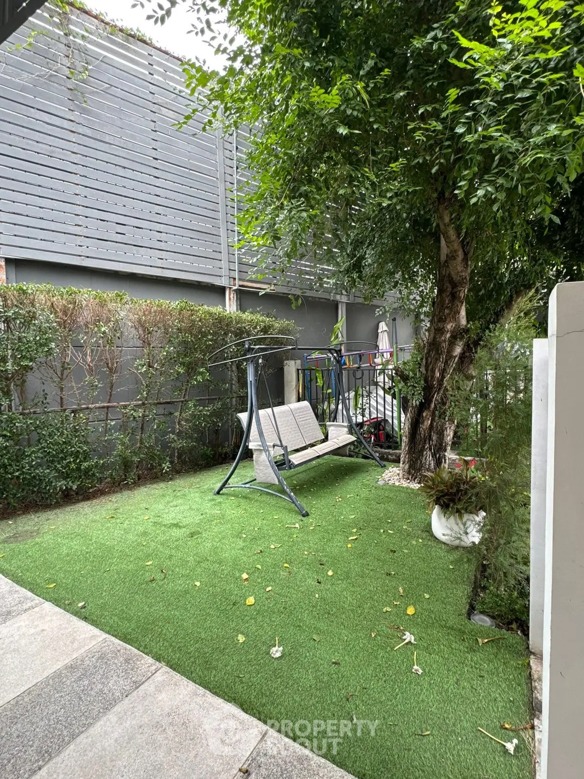 Charming garden with swing and lush greenery, perfect for relaxation and outdoor enjoyment.