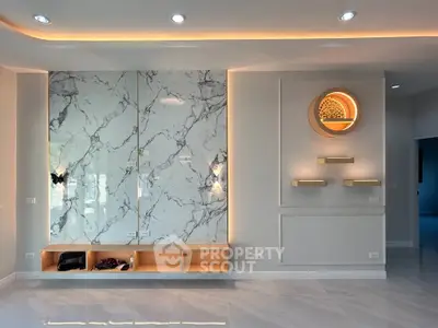 Elegant modern living room with marble accent wall and ambient lighting