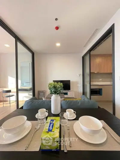 Modern open-plan living room with dining area, stylish decor, and natural light.