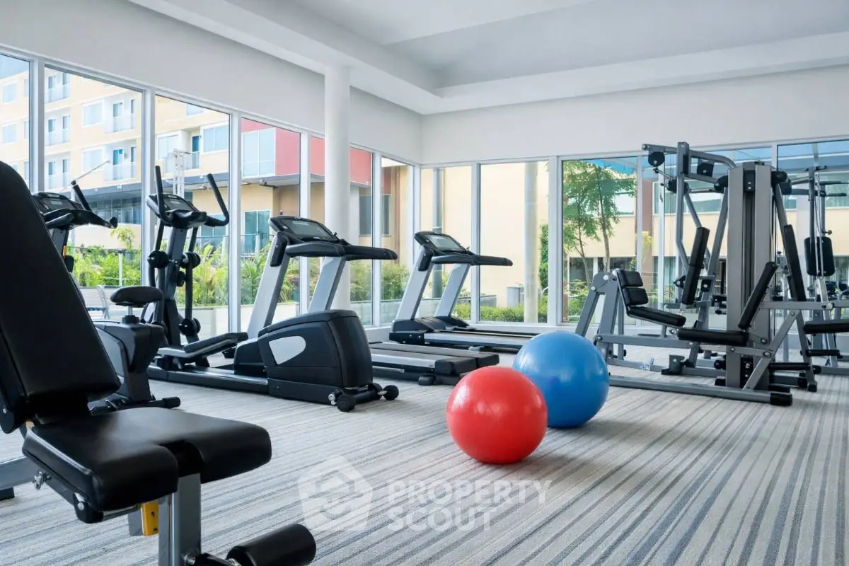 Modern gym with state-of-the-art equipment and vibrant exercise balls in a bright setting.