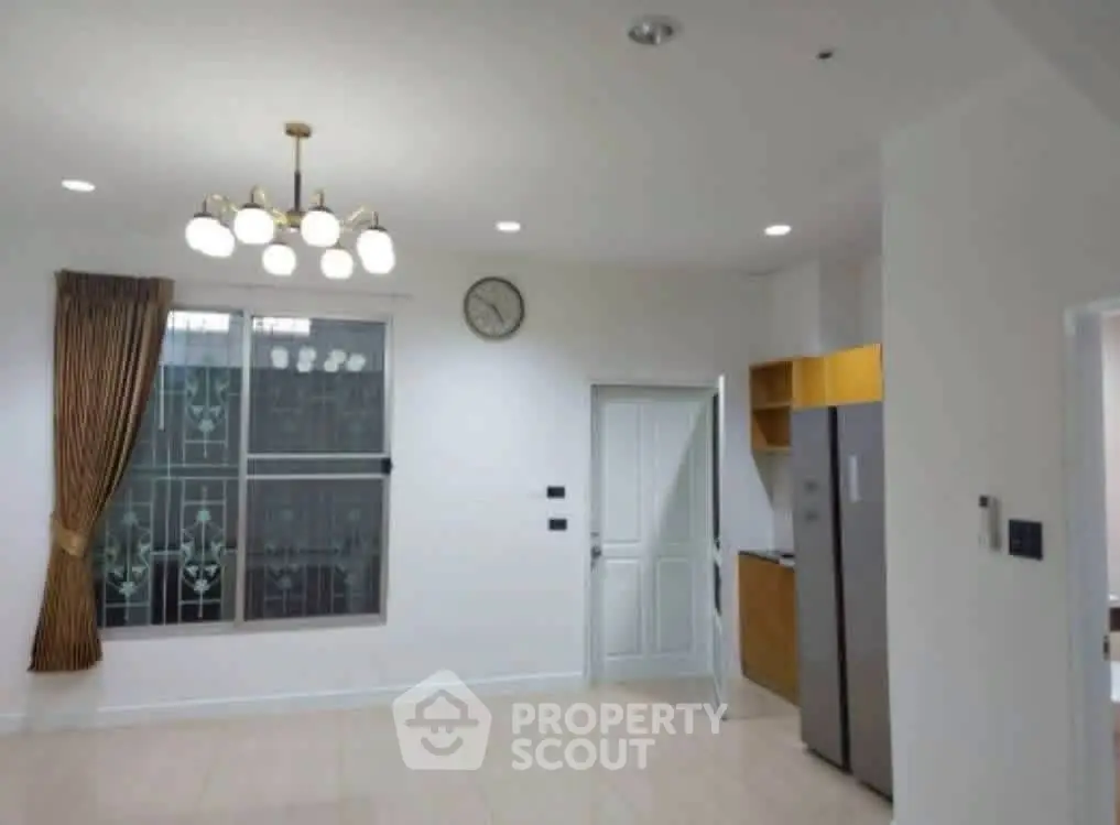 Spacious kitchen with modern lighting and stainless steel fridge in a bright, open layout.