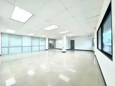 Spacious office space with large windows and modern lighting