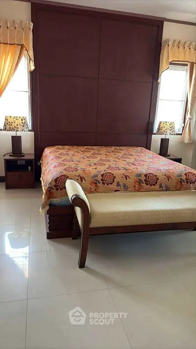 Spacious bedroom with elegant decor and large bed, perfect for relaxation.