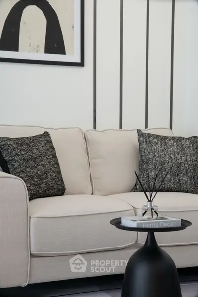 Stylish modern living room with elegant beige sofa and chic black side table.