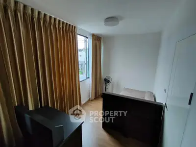 Cozy bedroom with large window and modern furnishings, perfect for a serene retreat.