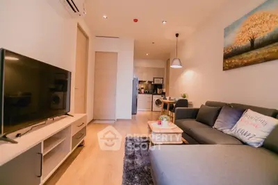 Modern living room with cozy sofa and open kitchen layout in stylish apartment.