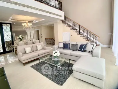 Luxurious living room with elegant staircase and plush seating in a modern home