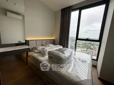 Modern bedroom with large window offering stunning city view