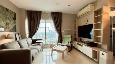 Modern living room with city view, stylish furniture, and natural light.
