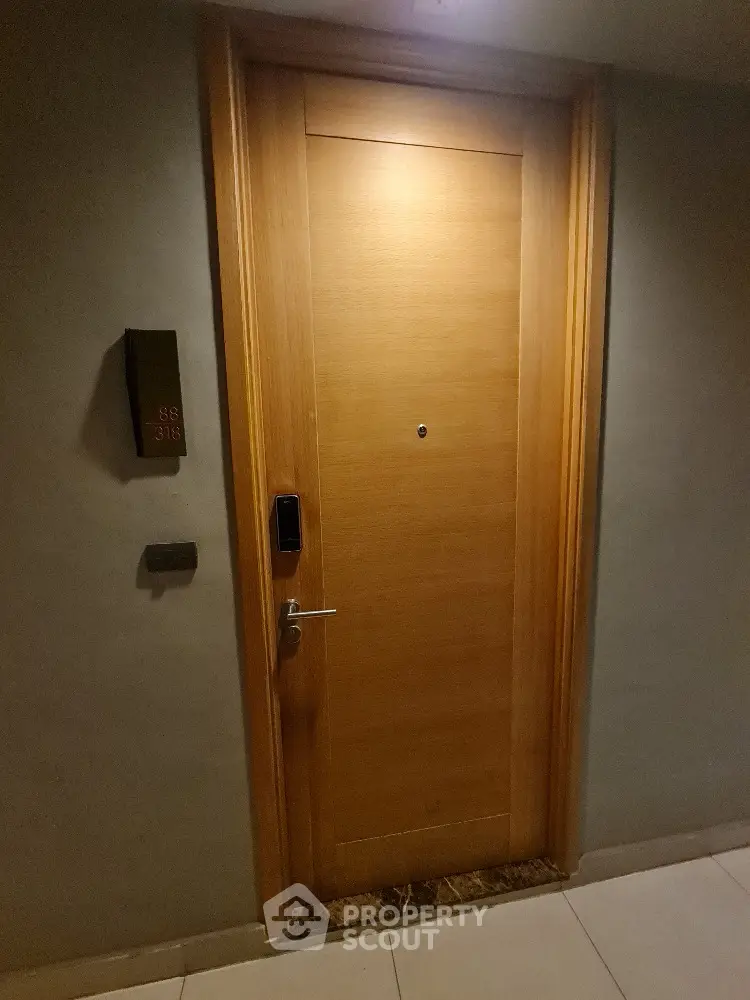Elegant wooden apartment door with modern electronic lock in upscale building