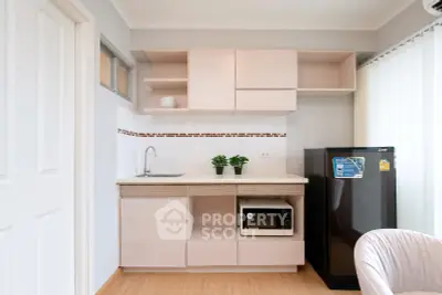 Modern compact kitchen with sleek cabinetry and appliances in a stylish apartment.