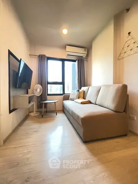 Cozy modern living room with large sofa and wall-mounted TV, perfect for relaxation.