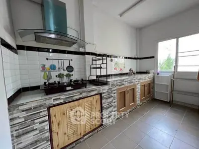 Spacious kitchen with modern gas stove and ample storage in a bright, airy setting.
