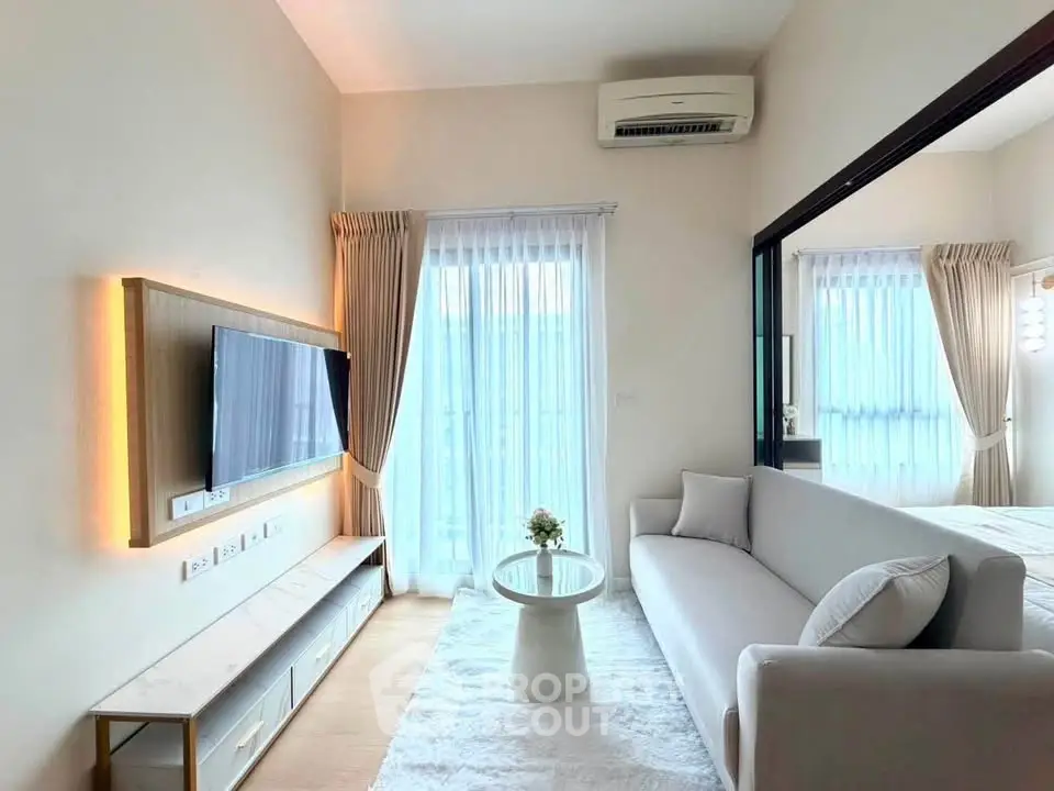 Modern living room with sleek design, featuring a wall-mounted TV, plush sofa, and elegant decor.