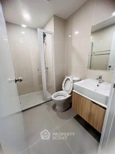 Modern bathroom with sleek shower and stylish vanity in contemporary apartment.