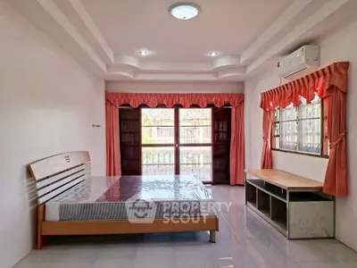 Spacious bedroom with large windows and natural light, featuring modern furniture and air conditioning.