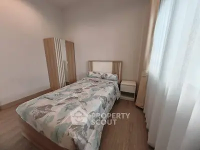 Cozy bedroom with single bed and natural light, perfect for relaxation.