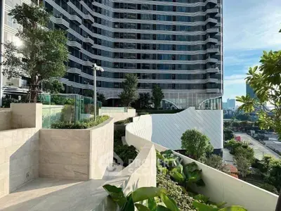 Modern high-rise building with lush landscaping and city view