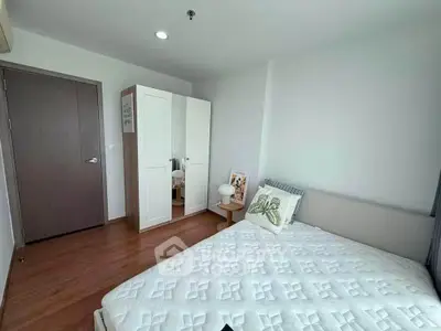 Modern bedroom with stylish decor and ample natural light, featuring a comfortable bed and sleek wardrobe.