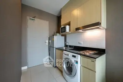 Modern compact kitchen with washing machine and sleek cabinetry