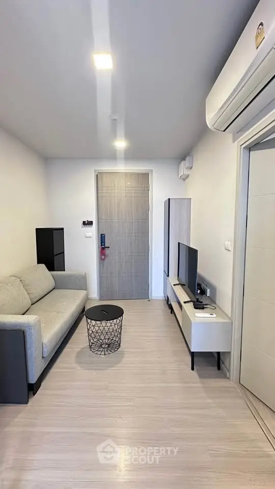 Modern living room with sleek furniture and air conditioning in a stylish apartment.