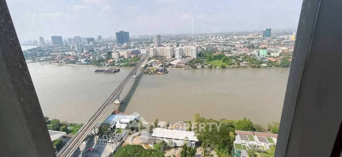 Stunning panoramic city and river view from high-rise building window.