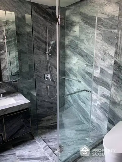 Luxurious marble bathroom with glass shower enclosure and modern fixtures