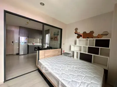 Modern bedroom with open kitchen layout and stylish shelving unit
