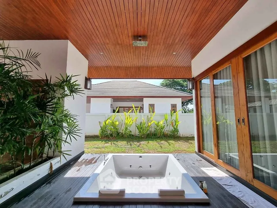 Luxurious outdoor jacuzzi area with wooden ceiling and garden view