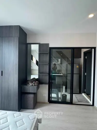 Modern bedroom with sleek wardrobe and mirrored sliding doors in a stylish apartment.