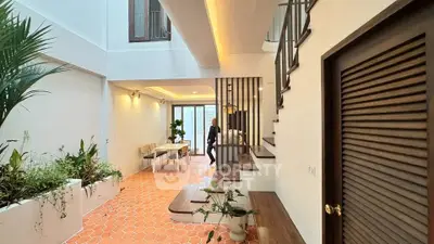 Stunning open-plan interior with modern design and lush greenery, perfect for stylish living.